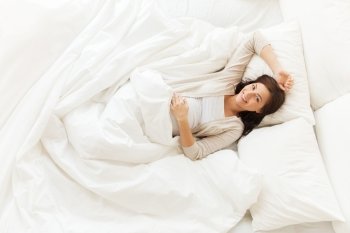 pregnancy, rest, people and expectation concept - happy pregnant woman lying in bed at home bedroom