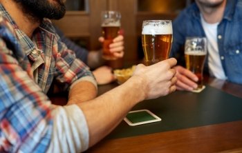people, leisure, drinks and celebration concept - happy male friends drinking beer at bar or pub