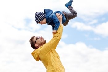family, childhood, fatherhood, leisure and people concept - happy father and little son playing and having fun outdoors