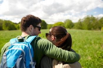 travel, hiking, backpacking, tourism and people concept - happy couple with backpacks hugging and walking along country road