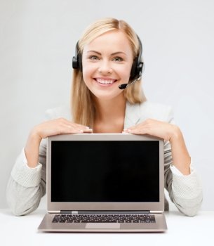 education, business, technology, advertisement and people concept - smiling young woman or helpline operator in headset with blank screen on laptop computer
