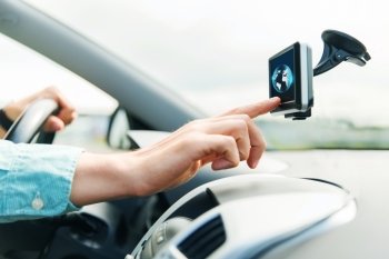transport, business trip, technology, navigation and people concept - close up of male hand using gps navigator with earth globe on screen while driving car