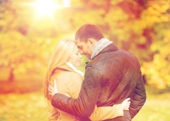 holidays, love, travel, tourism, relationship and dating concept - romantic couple kissing in the autumn park