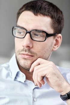 business, people and work concept - portrait of  businessman in eyeglasses at office