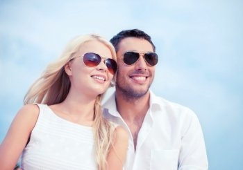 summer holidays and dating concept - couple in shades at sea side. couple in shades at sea side
