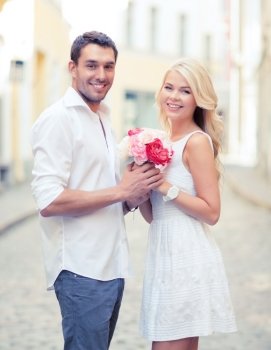summer holidays and dating concept - couple with bouquet of flowers in the city. couple with flowers in the city