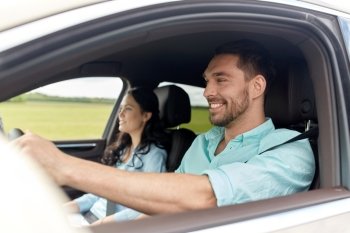 leisure, road trip, travel, family and people concept - happy man and woman driving in car