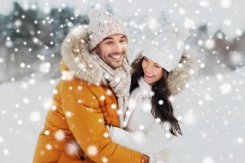 people, season, love and leisure concept - happy couple hugging and laughing outdoors in winter