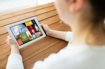 technology, people and advertisement concept - close up of woman with internet news on tablet pc computer screen on wooden table