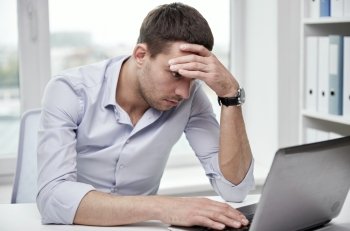 business, people, deadline and technology concept - stressed businessman with laptop computer at office