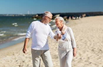 family, age, travel, tourism and people concept - happy senior couple holding hands and walking on summer beach