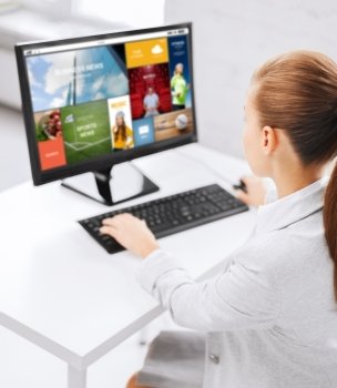 business, people, technology, media and education concept - businesswoman or student girl with internet page on computer screen sitting at office table