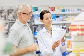 medicine, pharmaceutics, health care and people concept - happy pharmacist and senior man customer with drug and prescription at drugstore