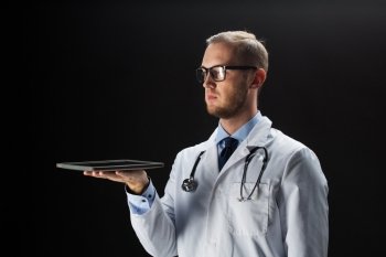 healthcare, people, technology and medicine concept - male doctor in white coat with stethoscope and tablet pc computer over black background
