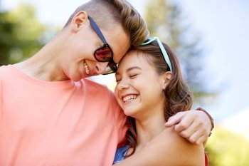 holidays, vacation, love and people concept - happy smiling teenage couple hugging at summer