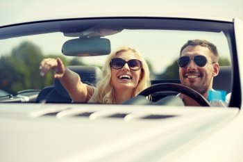 road trip, travel, couple and people concept - happy man and woman driving in cabriolet car outdoors