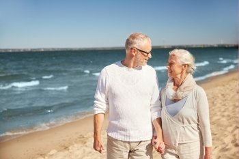family, age, travel, tourism and people concept - happy senior couple walking along summer beach