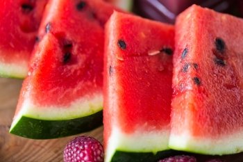 healthy eating, food, dieting and vegetarian concept - close up of watermelon slices on wooden table