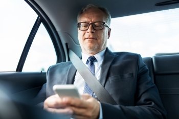 transport, business trip, technology and people concept - senior businessman texting on smartphone and driving on car back seat