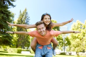 holidays, vacation, love and people concept - happy smiling teenage couple having fun at summer park