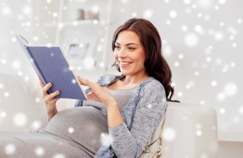pregnancy, winter, christmas and people concept - smiling pregnant woman lying on sofa and reading book over snow