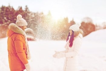 people, season, love and leisure concept - happy couple playing with snow in winter