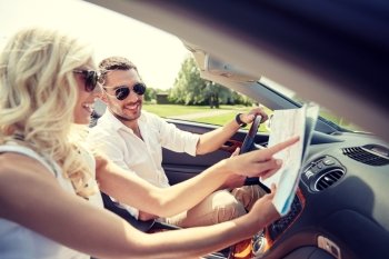 road trip, travel, summer vacation and people concept - happy man and woman driving in cabriolet car with map