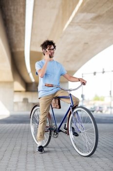 people, communication, technology, leisure and lifestyle - hipster man calling on smartphone and fixed gear bike on city street