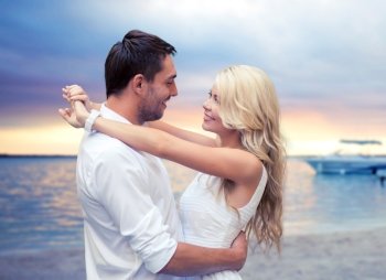 summer holidays, people, love, travel and dating concept - happy couple hugging over sunset beach background