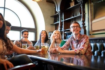 people, leisure, friendship and entertainment concept - happy friends drinking beer and watching sport game or football match at bar or pub
