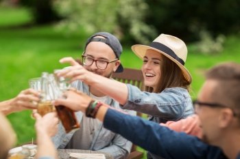 leisure, holidays, people, reunion and celebration concept - happy friends clinking glasses and celebrating at summer garden party