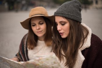 Female friends consulting a city map in the winter