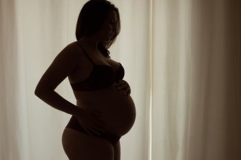Silhouette of a pregnant woman at home - Natural Light