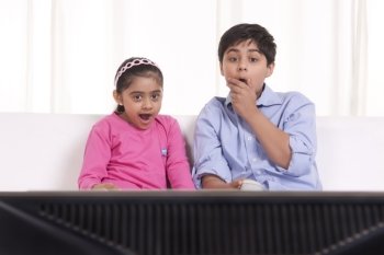 Shocked brother and sister watching tv
