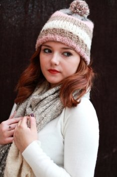 Portrait of a pretty teenage girl with redhair all wrapped up against the cold