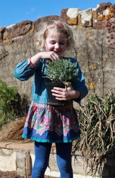 Pretty blonde haired girl holding a pot of lavender