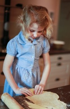 Young girl who is making pastry in the kitchen