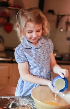 Young girl pouring water into a mixing bowl