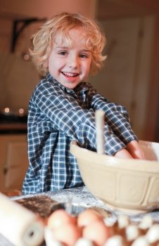 Little boy having fun mixing flour in a bowl