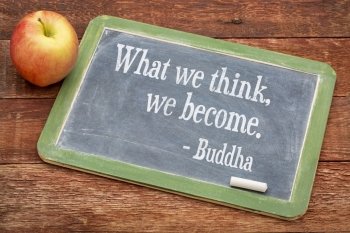 What we think we become - Buddha quote  on a slate blackboard against red barn wood