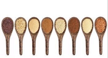 a variety of gluten free grains (from left: black quinoa, buckwheat, amaranth, teff, sorghum, kaniwa, millet, and brown rice) - set of wooden spoons isolated on white