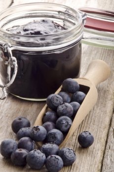 blueberry jam and fresh blueberries on a wooden spoon  
