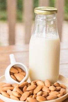 Bottle of almond milk on wooden table, stock photo