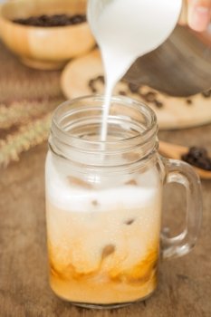 Milk pouring for fresh iced coffee, stock photo