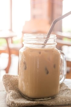Iced milk coffee glass on wooden table with vintage filter effect, stock photo