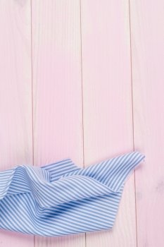 Blue striped towel over the surface of a wooden table.