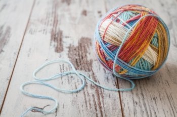 Colorful balls of yarn for knitting on white wooden table