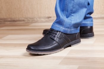 male legs in jeans and shoes in interere