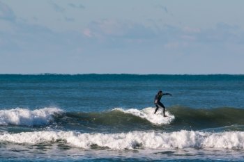surfer black wetsuit riding the wave
