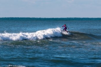 surfer violet wetsuit riding the wave